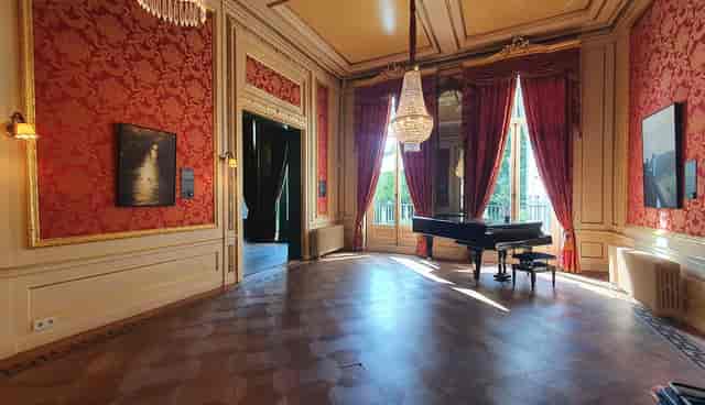 Elegant museum event space with ornate chandelier, perfect for receptions and performances.