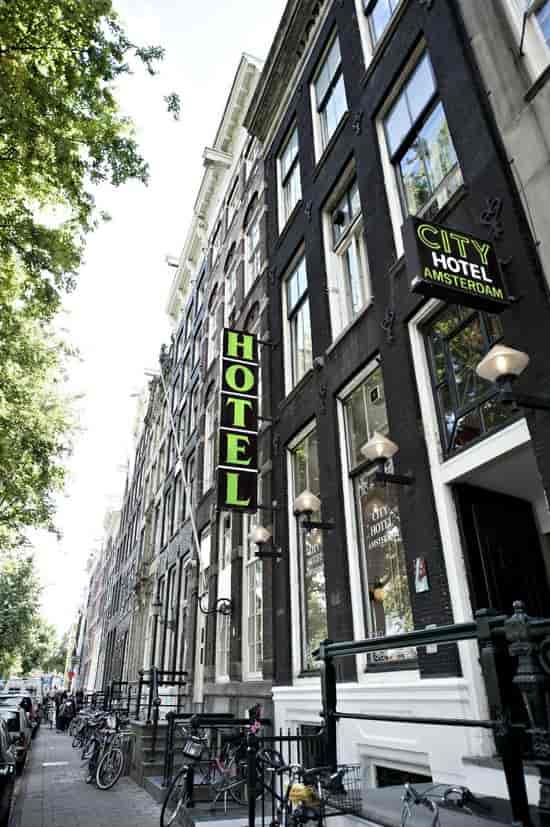 Bar at City Hotel Amsterdam with vibrant signage, ideal for events and accommodations.