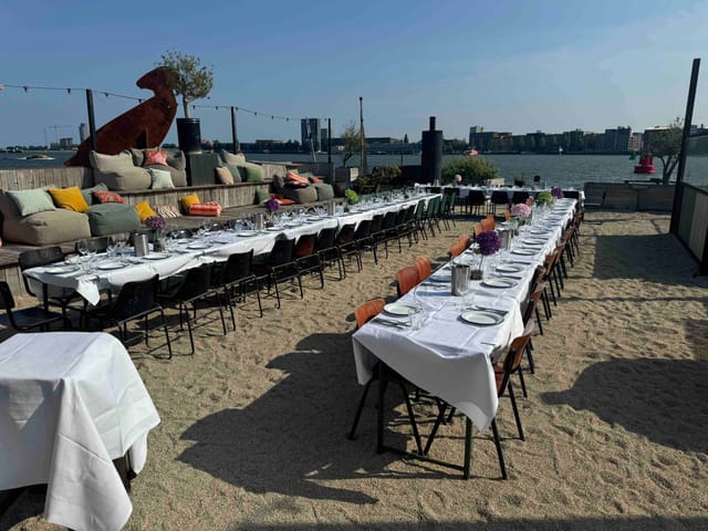 Outdoor banquet space in Hangar Amsterdam with elegant table by the waterfront.