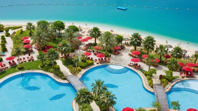 Beachfront Meeting Plus 6 venue with red umbrellas, ideal for outdoor corporate retreats.