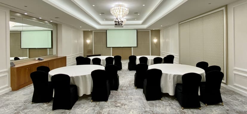 Elegant meeting room in Sofitel Dubai, featuring round tables and ideal for corporate events.