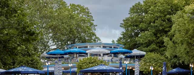 "Outdoor event venue at Proeflokaal 't Blauwe Theehuis with greenery and blue umbrellas."