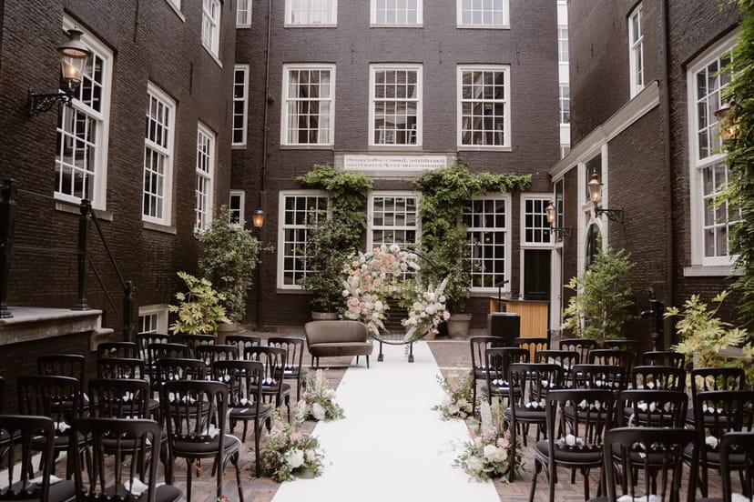 Intimate wedding venue in The Dylan Amsterdam's elegant atrium with floral decor.