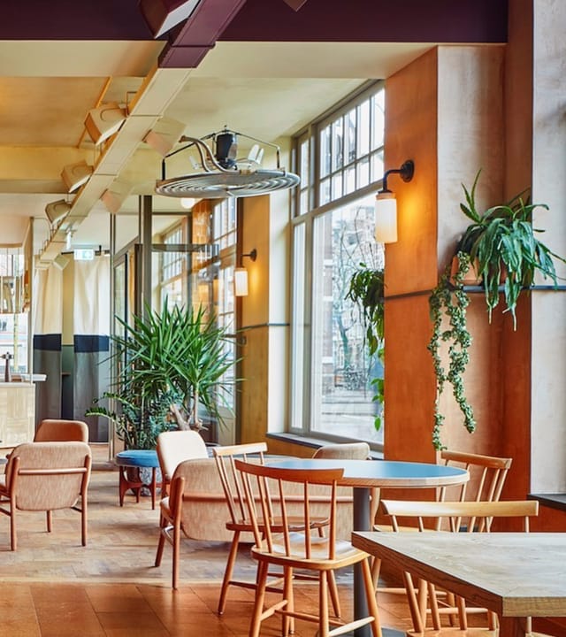 Modern event space in Karavaan Amsterdam with natural light and greenery for meetings.