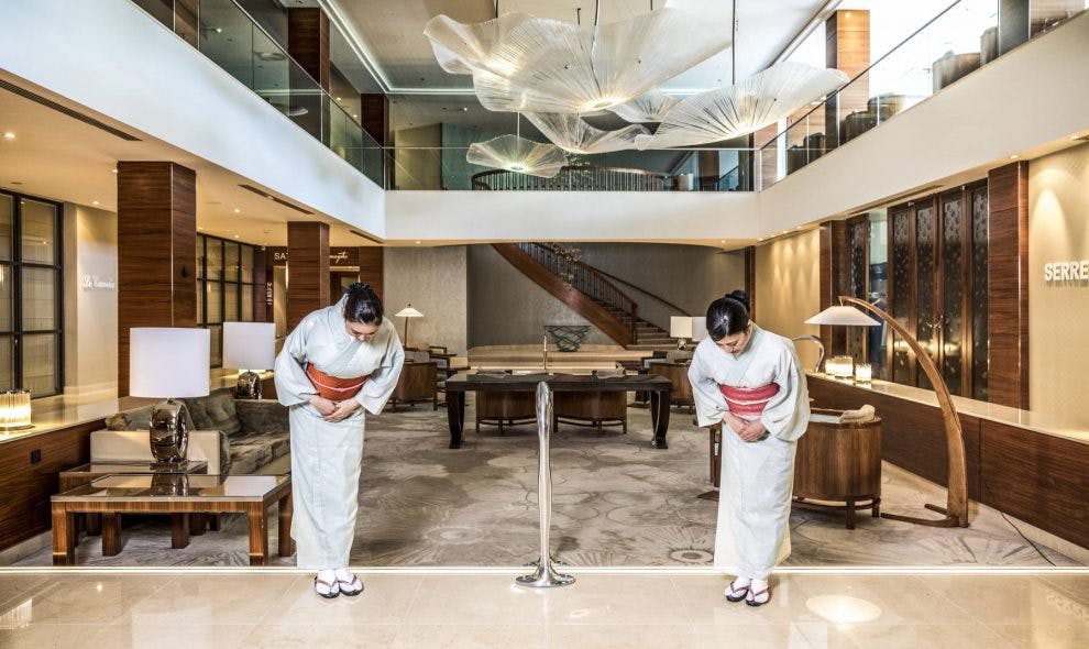 Hotel Okura Amsterdam lounge with staff bowing, perfect for upscale events and meetings.