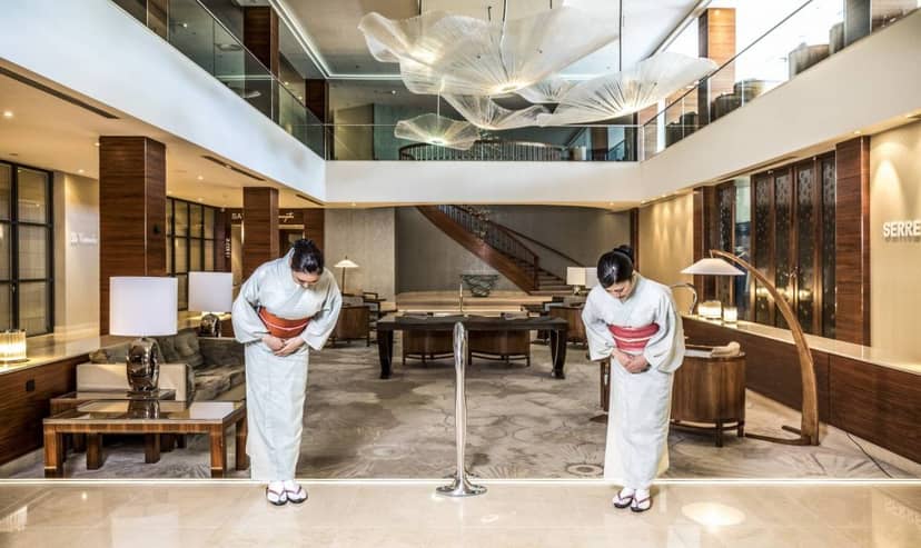 Hotel Okura Amsterdam lounge with staff bowing, perfect for upscale events and meetings.
