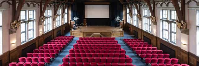 Queen Maxima Hall auditorium with red seating, perfect for conferences and seminars.