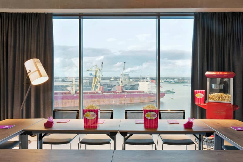Modern meeting space with waterfront view in Moxy Amsterdam for corporate events.