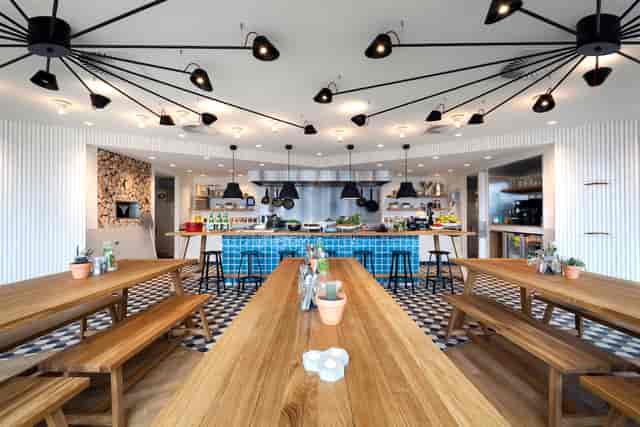 Modern event space in Zoku Amsterdam with communal dining for networking and team-building.
