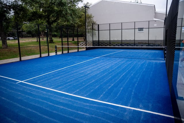Blue tennis court at Bryanston Country Club for corporate events and networking.