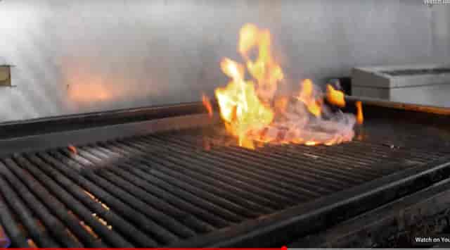 "Flaming grill at Smokin' Grill Steakhouse, perfect for catering events and outdoor parties."