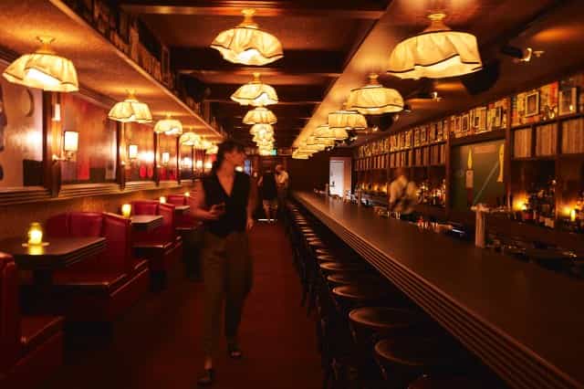 Stylish bar with cozy red booths, perfect for social gatherings and networking events.