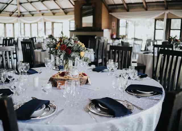 Elegant dining table with floral centerpieces in Trés Jolie event space for gatherings.