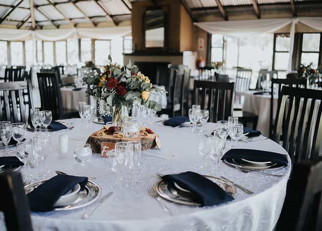 Elegant dining table with floral centerpieces in Trés Jolie event space for gatherings.
