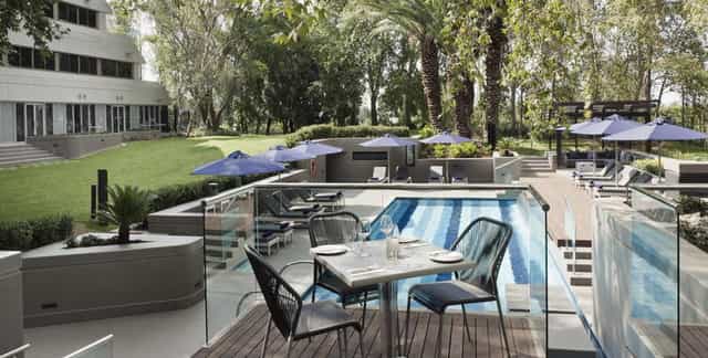 Elegant poolside dining area at Bistro, The Maslow Sandton – perfect for meetings and events.