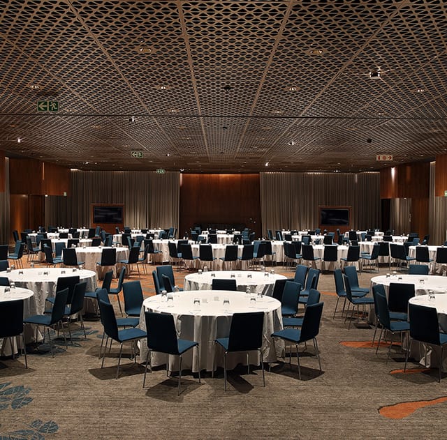 Formal conference venue with round tables and blue chairs at The Houghton Hotel.