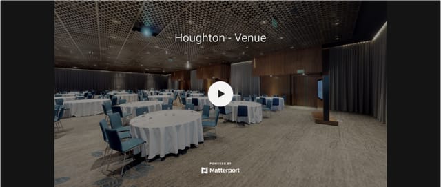 Spacious conference center with round tables and blue chairs at The Houghton Hotel.