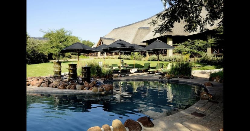 Outdoor auditorium at Indaba Hotel with serene pool, ideal for team-building events.