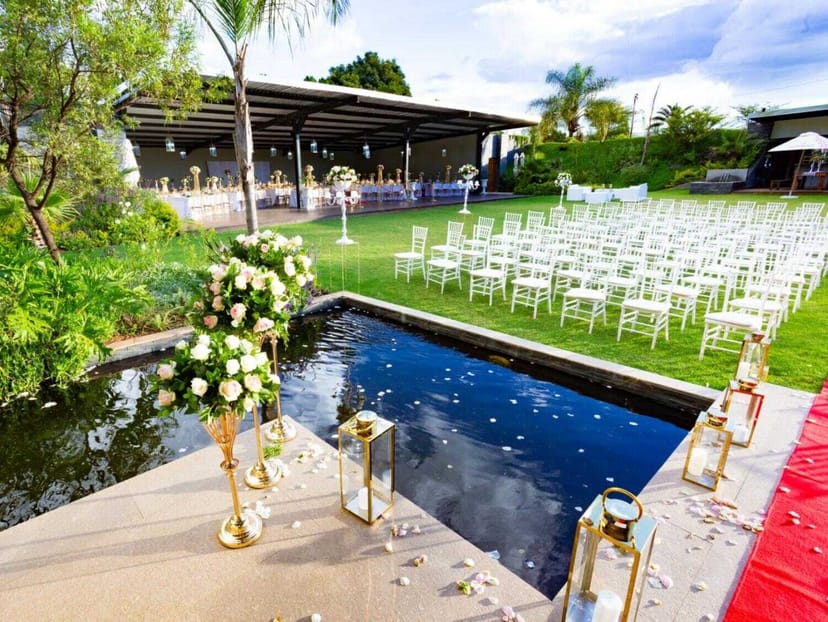 Koi Pond Pavilion outdoor wedding venue with elegant chairs and lush floral decor.