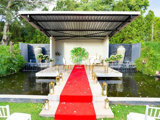 Koi Pond Pavilion wedding venue with elegant stage and lush greenery.