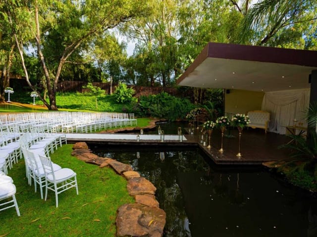 Koi Pond Pavilion outdoor wedding venue with floral stage and serene water feature.
