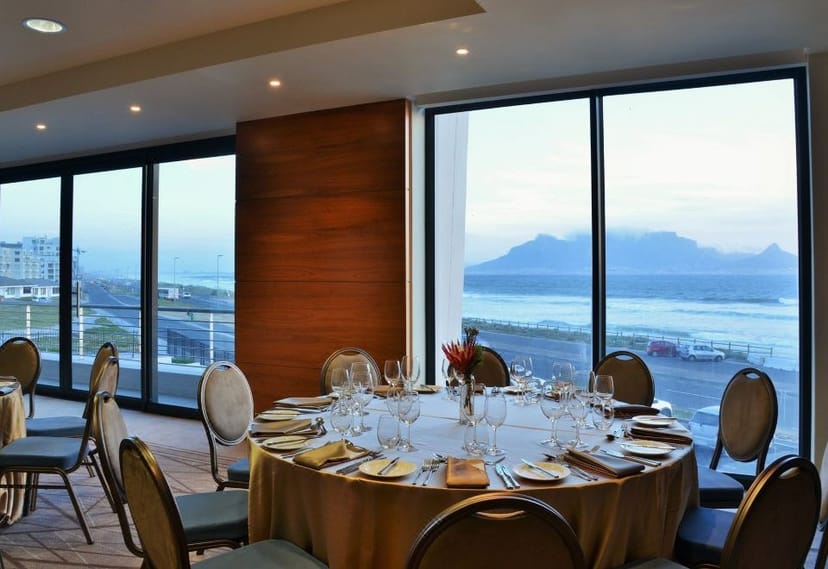 Elegant dining table with floral centerpieces at Blaauwberg Beach Hotel event venue.