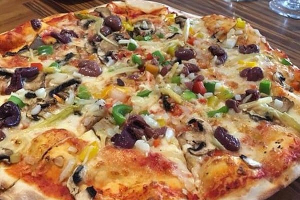 Vibrant pizza with fresh toppings for events at The Italian Club's conference hall.
