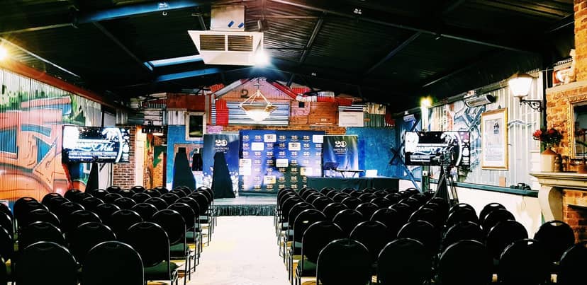 Red Roman Shed event space with black chairs, ideal for corporate meetings and presentations.