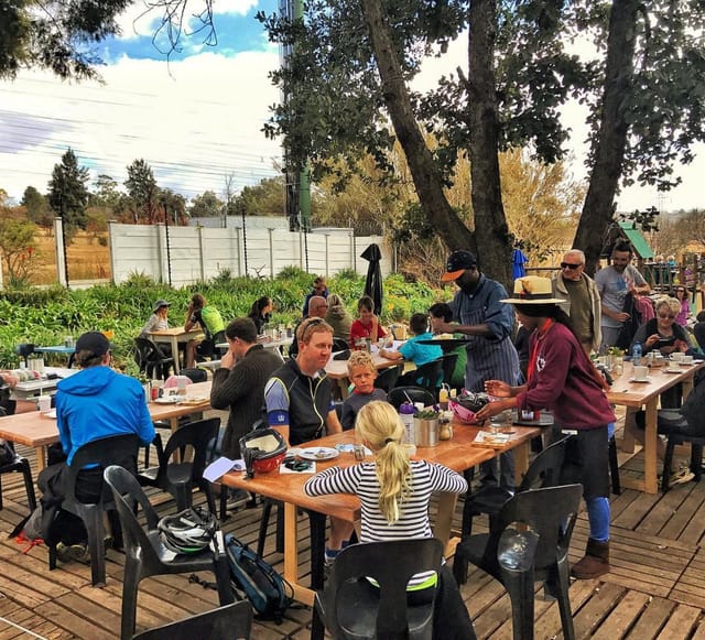 Outdoor dining at Delta Café with long wooden tables, ideal for networking events.