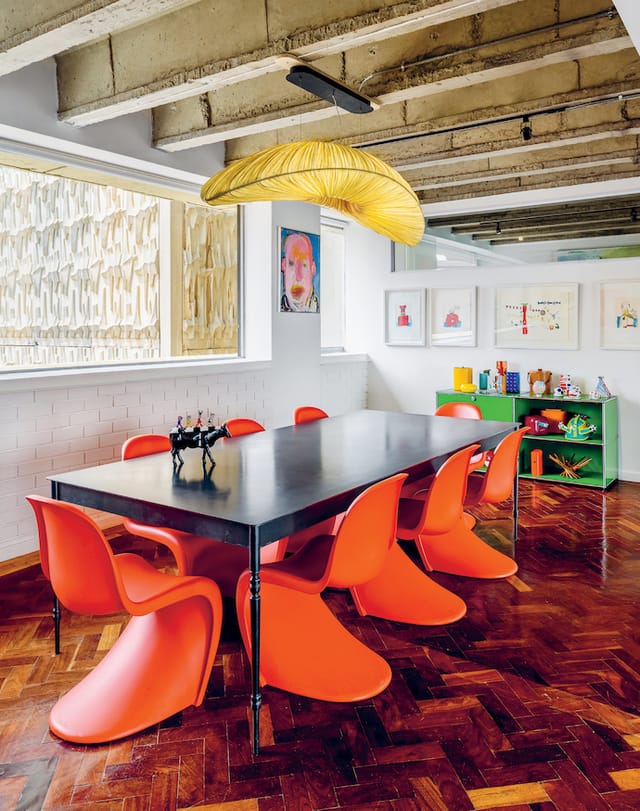 Vibrant meeting space in Braamfontein with sleek black table and orange chairs for workshops.