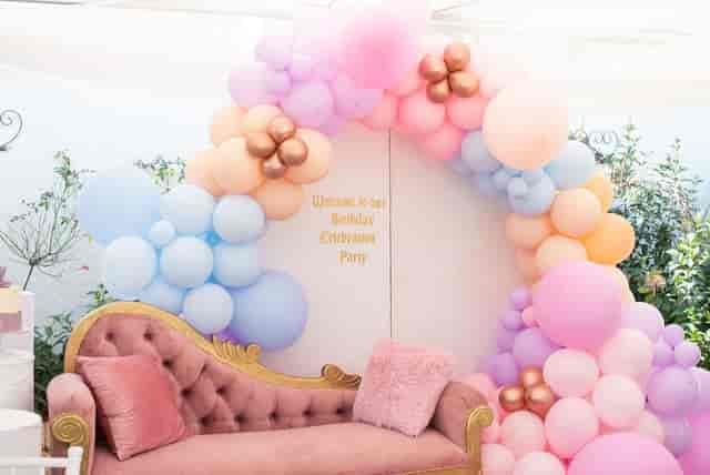 Balloon archway over a plush couch at a birthday celebration setup in Houghton Terrace.