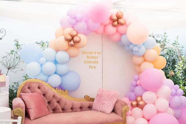Balloon archway over a plush couch at a birthday celebration setup in Houghton Terrace.