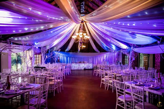 Elegant wedding venue with purple lighting and chic chairs at The Forest Walk.