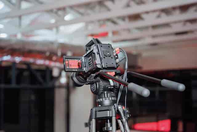 Professional video camera on tripod in Small Studio, ideal for hybrid events and live streaming.