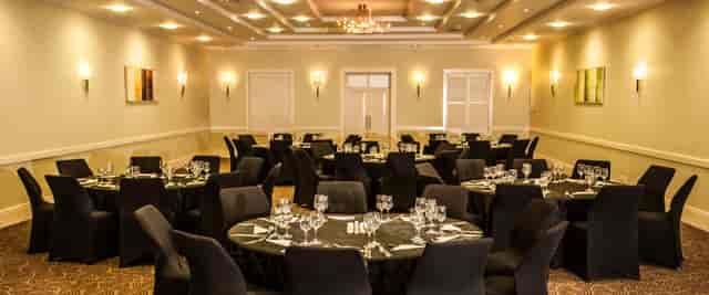 Auctioneers in Gold Reef City banquet room set for upscale corporate event with elegant tables.