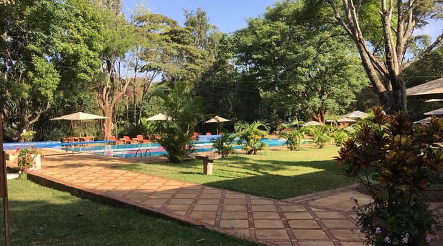 Outdoor event space at Muthaiga Country Club with lush greenery and pool area.