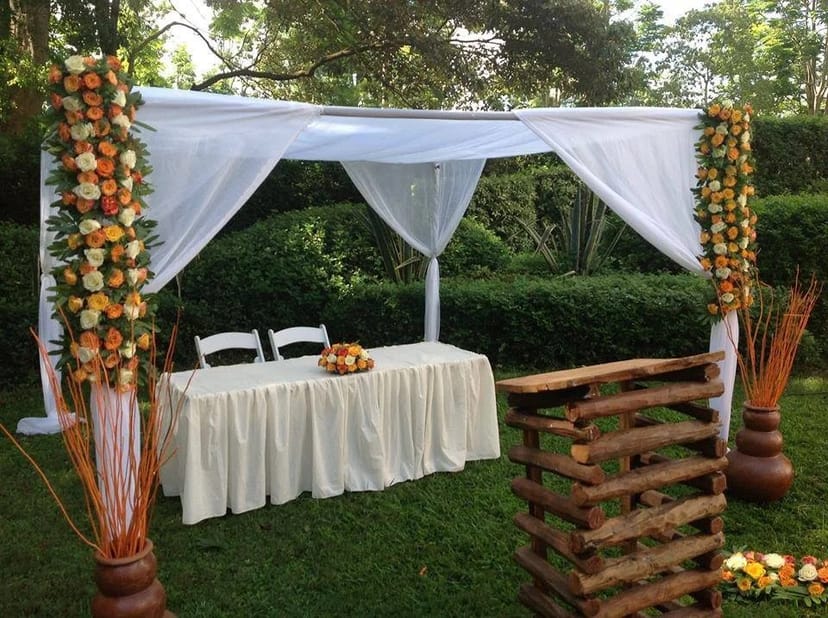 Elegant outdoor garden event setup with floral arch, ideal for weddings and gatherings.