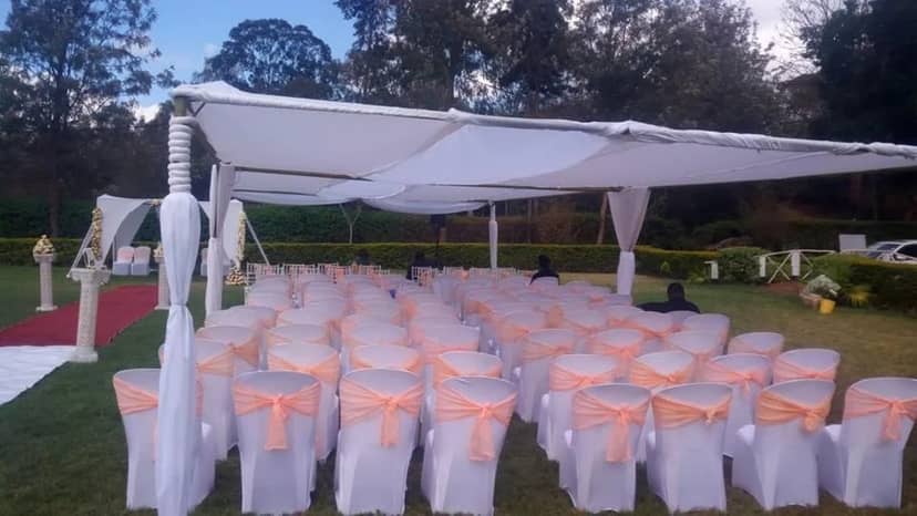 Aluhall Tent with white chairs and peach sashes, ideal for weddings or formal gatherings.