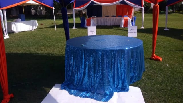 Vibrant outdoor event at KARLO Ground with elegant blue sequined table, Expat Events.