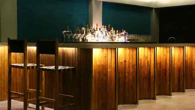 Stylish MUZE nightclub bar with warm wood counter, ideal for networking events.
