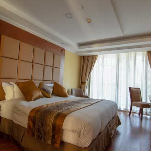 Luxurious seminar room with king-sized bed for relaxing conference accommodations.