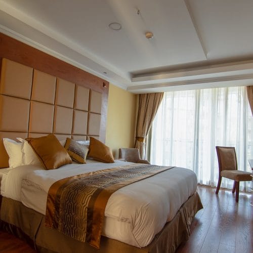 Luxurious seminar room with king-sized bed for relaxing conference accommodations.