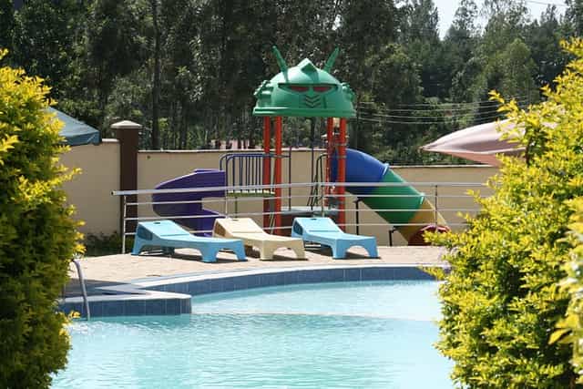 Calabash Hotel meeting rooms by vibrant pool and children's playground for family gatherings.
