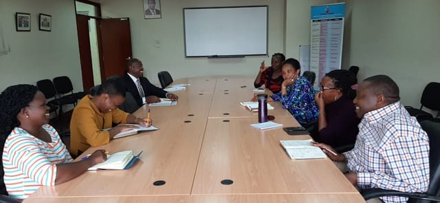 Kenyatta University conference room with engaged attendees in a collaborative meeting setting.