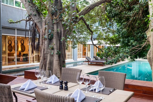 Elegant outdoor dining setup by a pool at Saxon Hotel, ideal for events and gatherings.