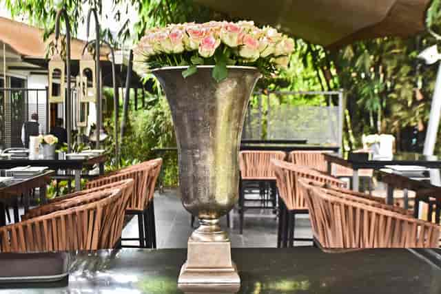Zen garden dining setup with silver vase of roses, ideal for upscale events and gatherings.