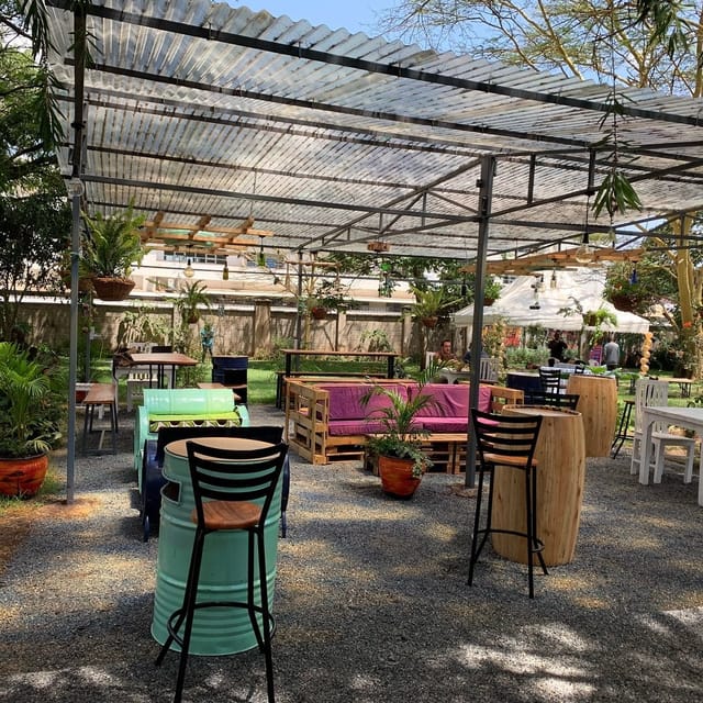 Outdoor event space with creative seating and lush greenery at Pallet Cafe.