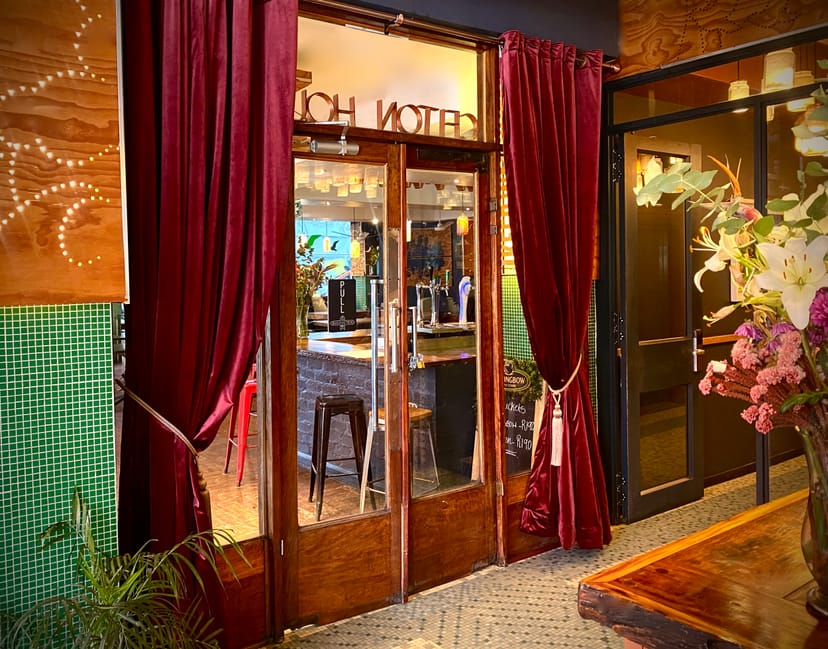 Charming Bannister Hotel entrance with rich burgundy curtains for events and gatherings.