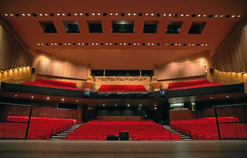 West End auditorium in Joburg Theatre, featuring tiered seating and vibrant red chairs.