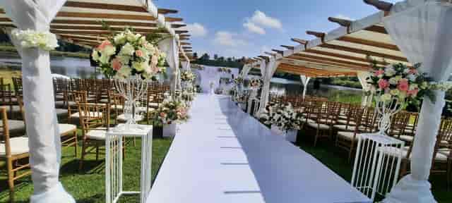 Outdoor wedding setup in Paradise Gardens with floral arrangements and serene water backdrop.